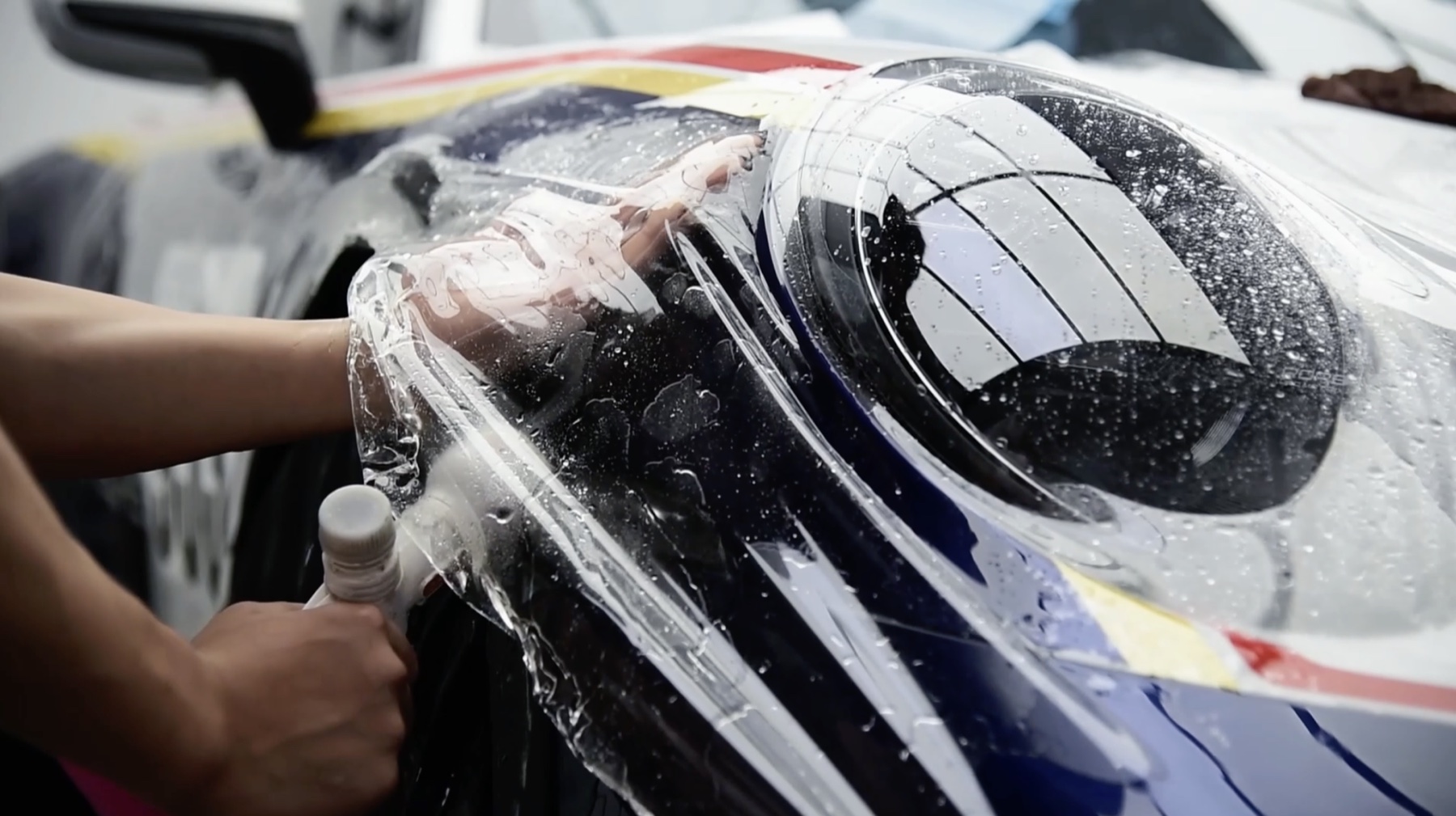 Paint protection film being installed around a vehicle headlight